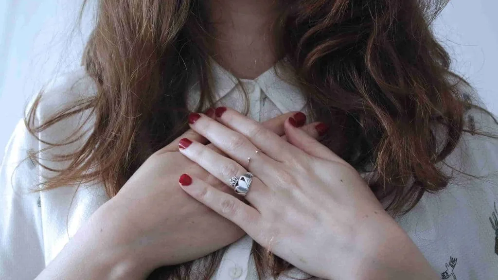 Accepting that life sucks right now: a woman rests both hands calmly over her chest