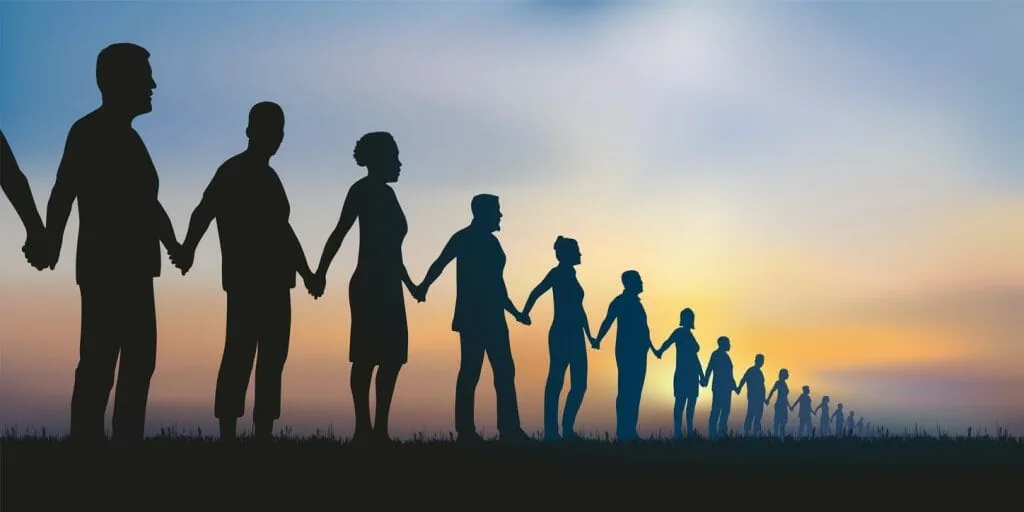 Finding people who share your ability: a long line of people holding hands at sunset