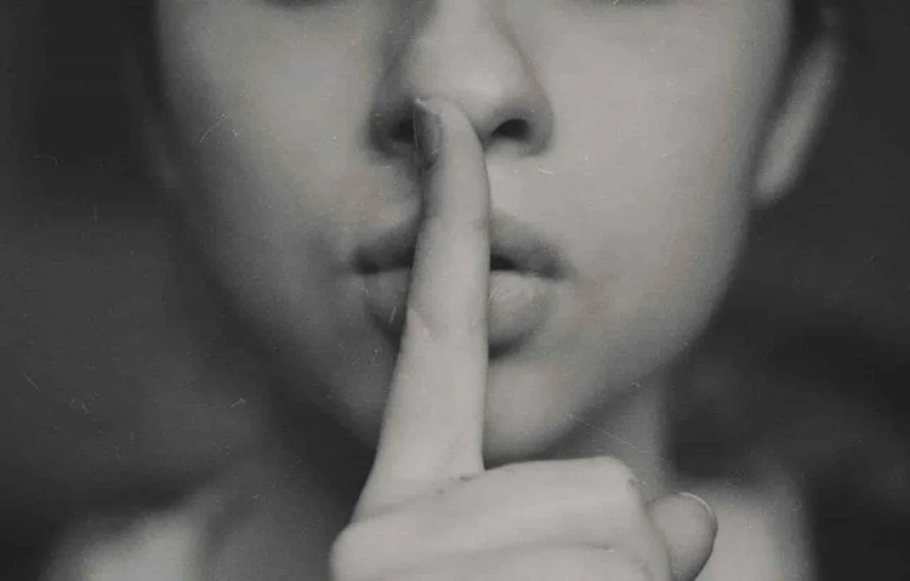 When you feel selfish but aren't: a black and white close-up of a woman holding a finger to her lips