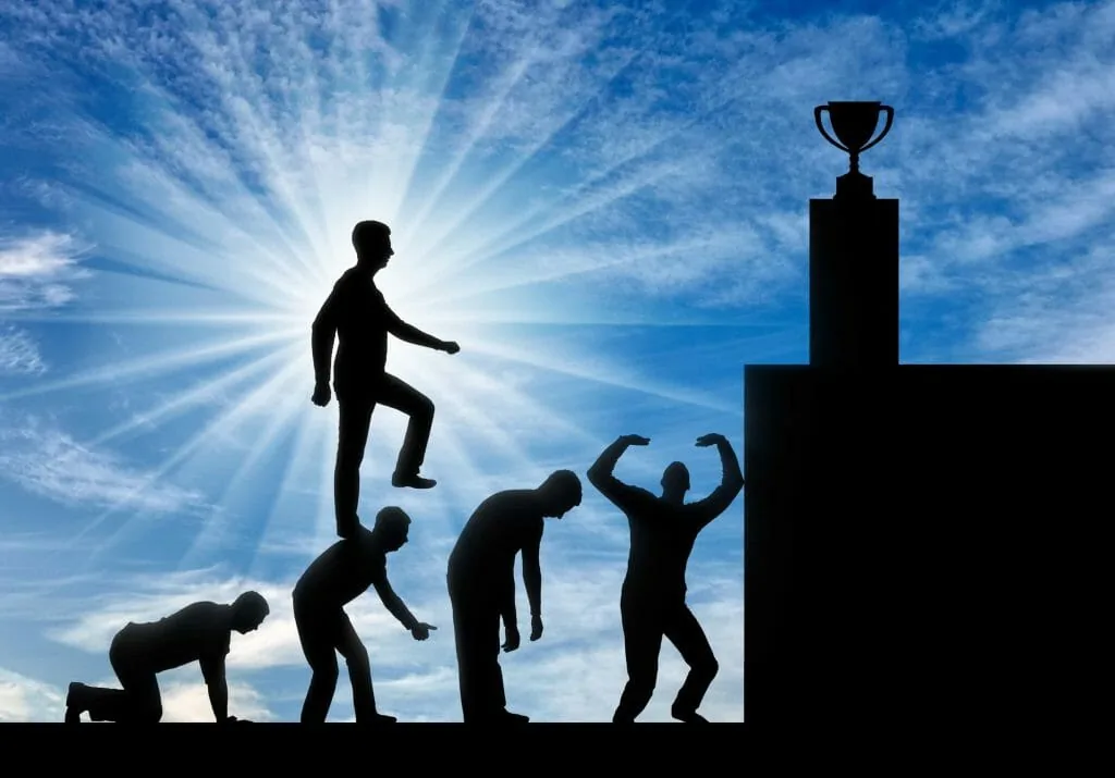 Am I selfish: a silhouette of a man climbing over the bent backs of others to reach a trophy