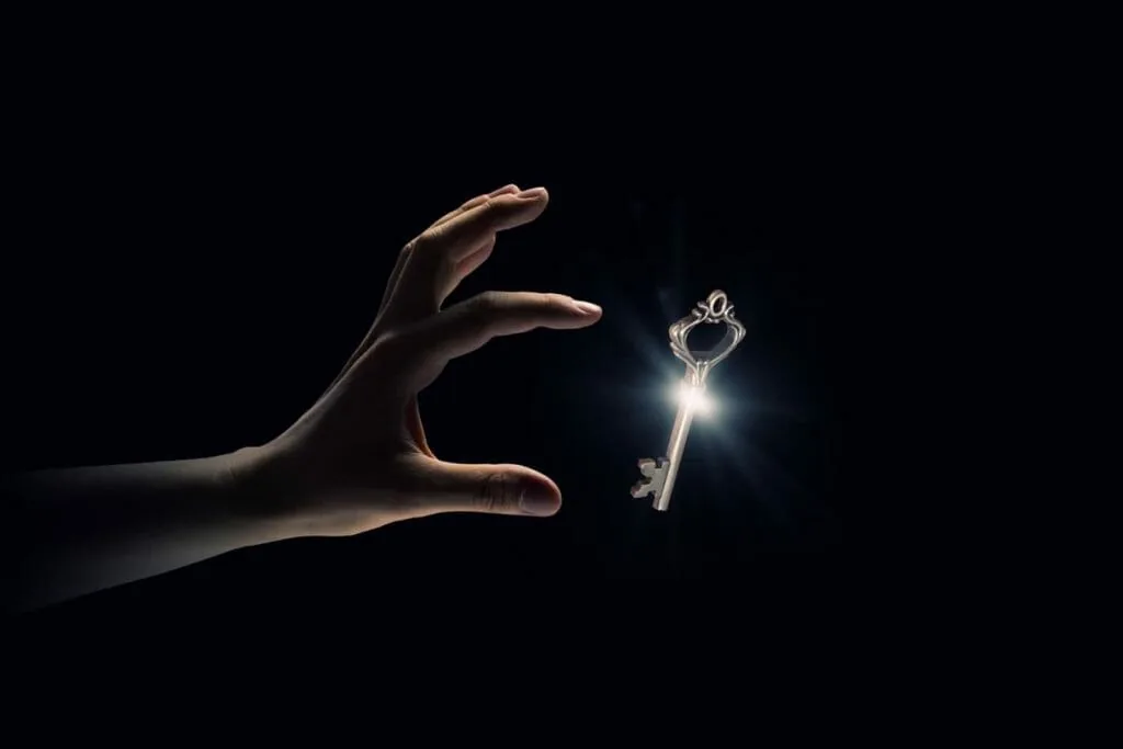 Innate ability: a hand reaching for a glowing old key in the dark