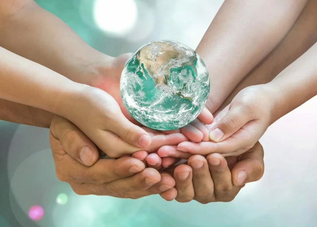 Using your innate ability to help others: many hands holding a glowing Earth