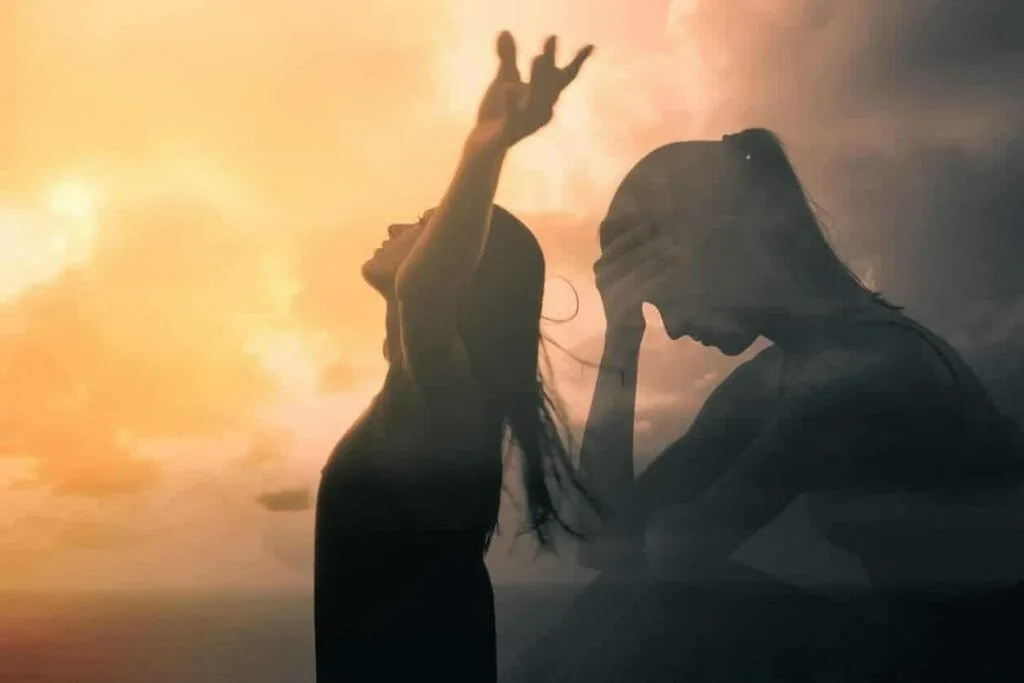 Deciding what stays and what goes when starting over: two overlapping silhouettes of a woman, one reaching up toward the sun and one with her head in her hands
