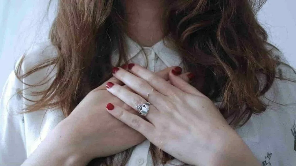 Looking after yourself when you have lost the joy in life: a woman with both hands resting over her heart
