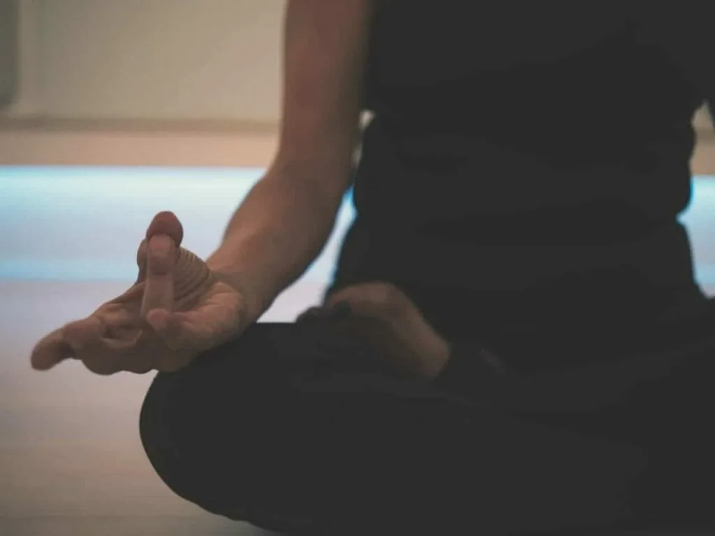 Redirecting your focus: a close view of a hand resting in a meditation pose