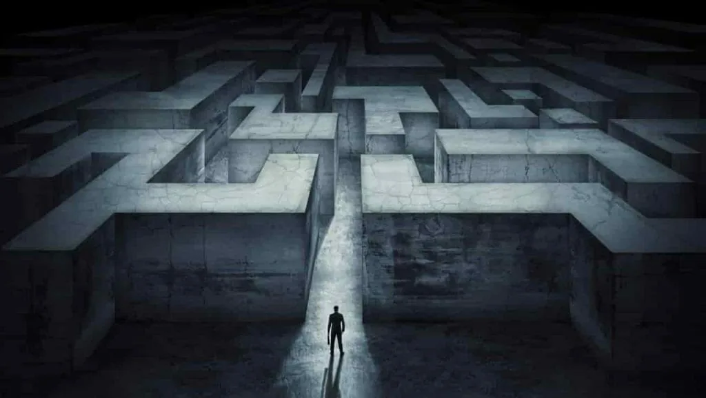 Living vicariously as escape: a lone man standing at the entrance of a huge dark concrete maze