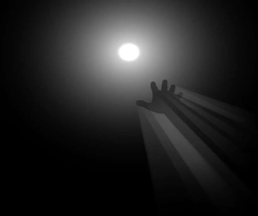Coraline method tunnel: a hand reaching toward a bright white light in the dark, with rays of light