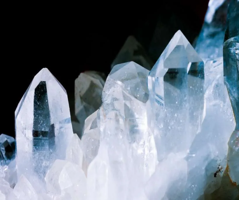 Crystals for the in your arms method: tall, clear quartz crystal points lit up on a black background